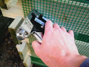 Pistol cu capse folosit pentru prinderea rețelei de plastic pe lada pentru compost